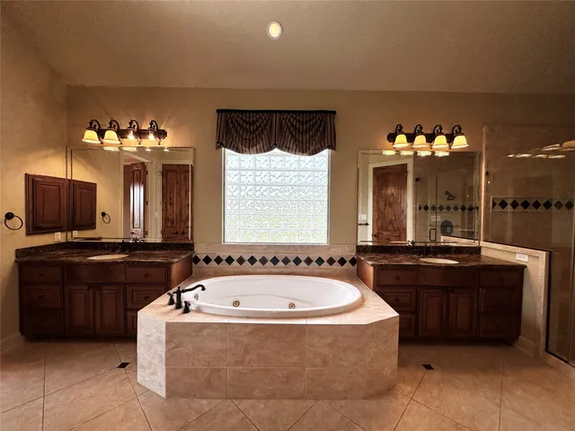 a bathroom with a bathtub sink and mirror