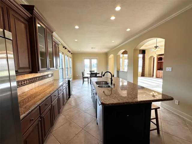 a dining hall with stainless steel appliances granite countertop a stove and a sink