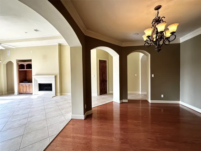a view of a hallway with wooden floor and a chandelier