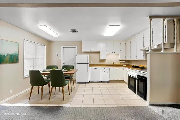 a kitchen with stainless steel appliances kitchen island granite countertop a stove a sink a dining table and chairs