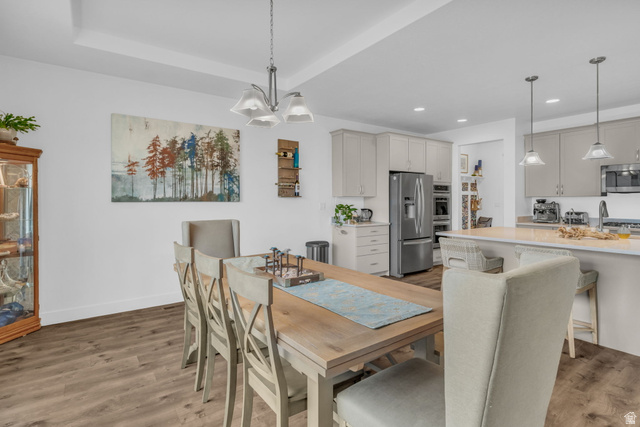 2454 West Jackson Street Mapleton, UT 84664 - Photo 13 of 63 Dining area featuring light wood-type flooring, a chandelier, and a raised ceiling