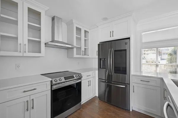 a kitchen with stainless steel appliances white cabinets and wooden floor