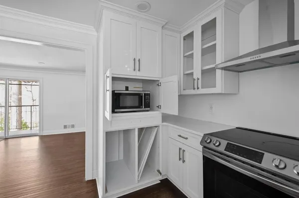 a kitchen with stainless steel appliances white cabinets and a stove top oven