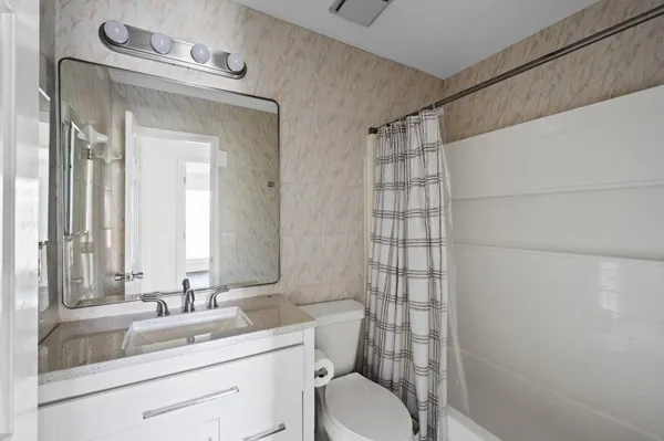 a bathroom with a sink a toilet and shower