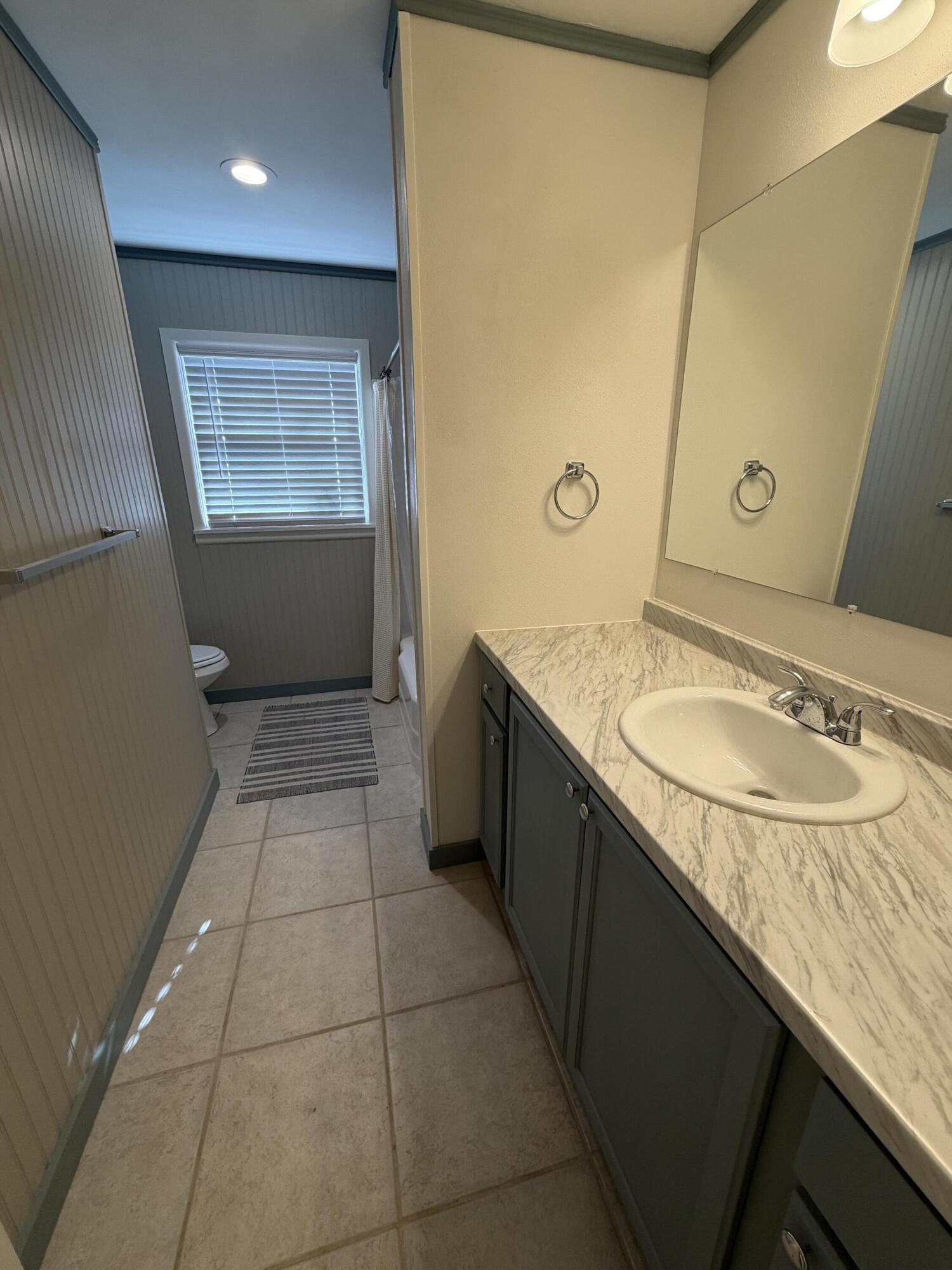 3113 38th Street Lubbock, TX 79413 - Photo 13 of 22 a bathroom with a granite countertop sink a mirror and a bathtub