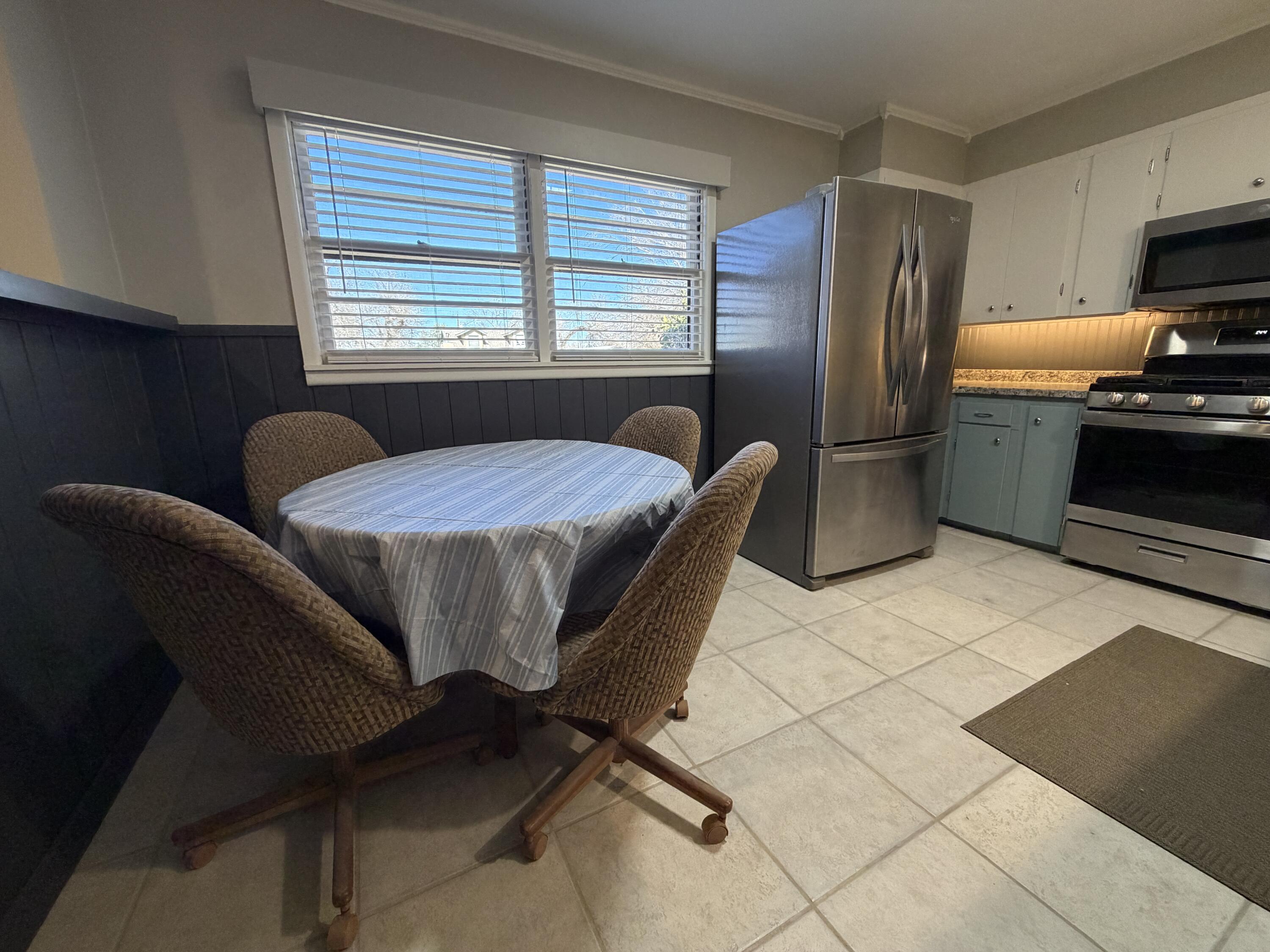 3113 38th Street Lubbock, TX 79413 - Photo 6 of 22 a dining room with stainless steel appliances kitchen island granite countertop furniture and a refrigerator
