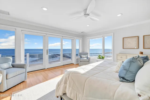 a bedroom with a bed and glass walk in closet