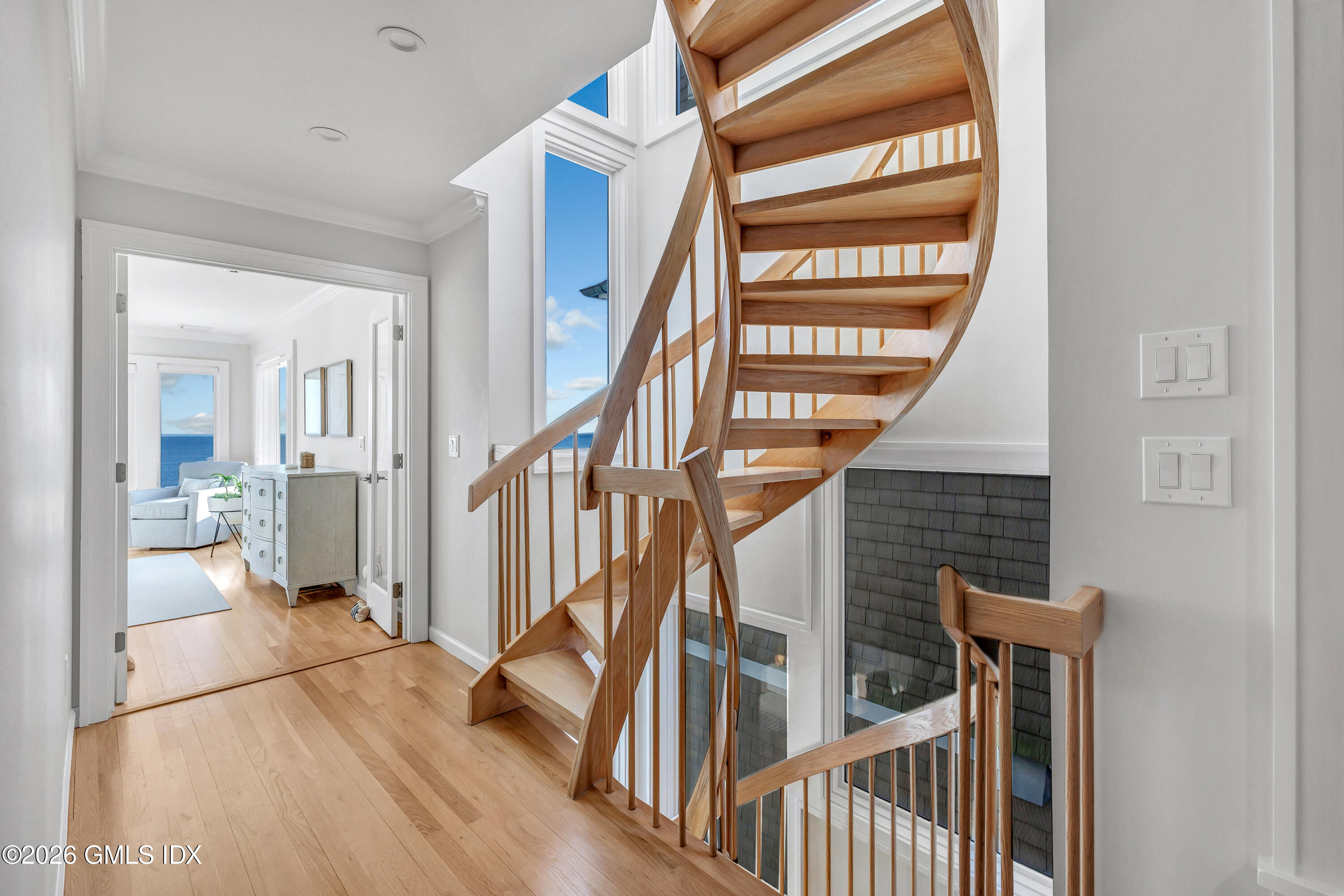 1053 Fairfield Beach Road Fairfield, CT 06824 - Photo 18 of 40 a view of staircase with lots of frames on wall and a window