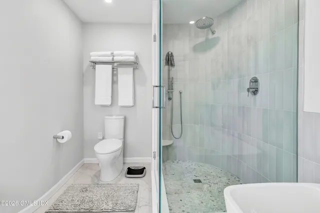 a bathroom with a toilet a sink and shower