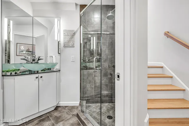 a bathroom with a granite countertop sink and shower