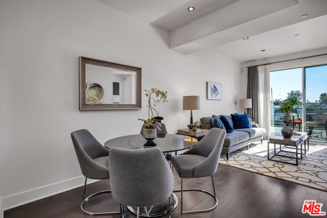 7857 West Manchester Avenue, Unit 201 Playa del Rey, CA 90293 - Photo 12 of 28 a dining room with furniture a large window and wooden floor