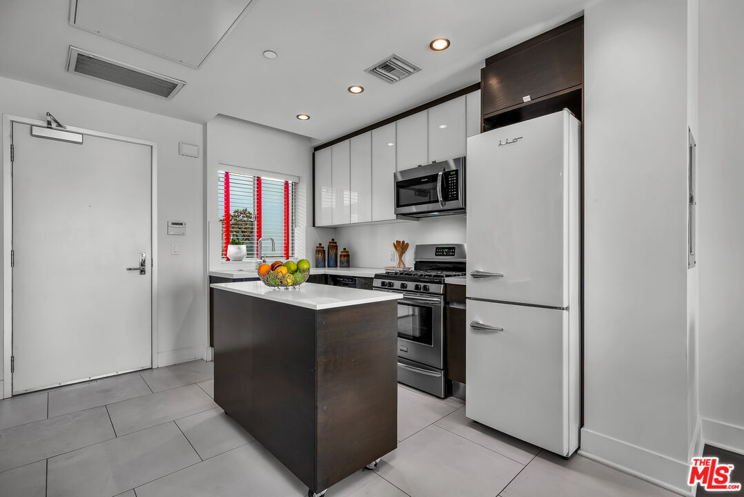7857 West Manchester Avenue, Unit 201 Playa del Rey, CA 90293 - Photo 16 of 28 a kitchen with stainless steel appliances a refrigerator stove microwave and sink