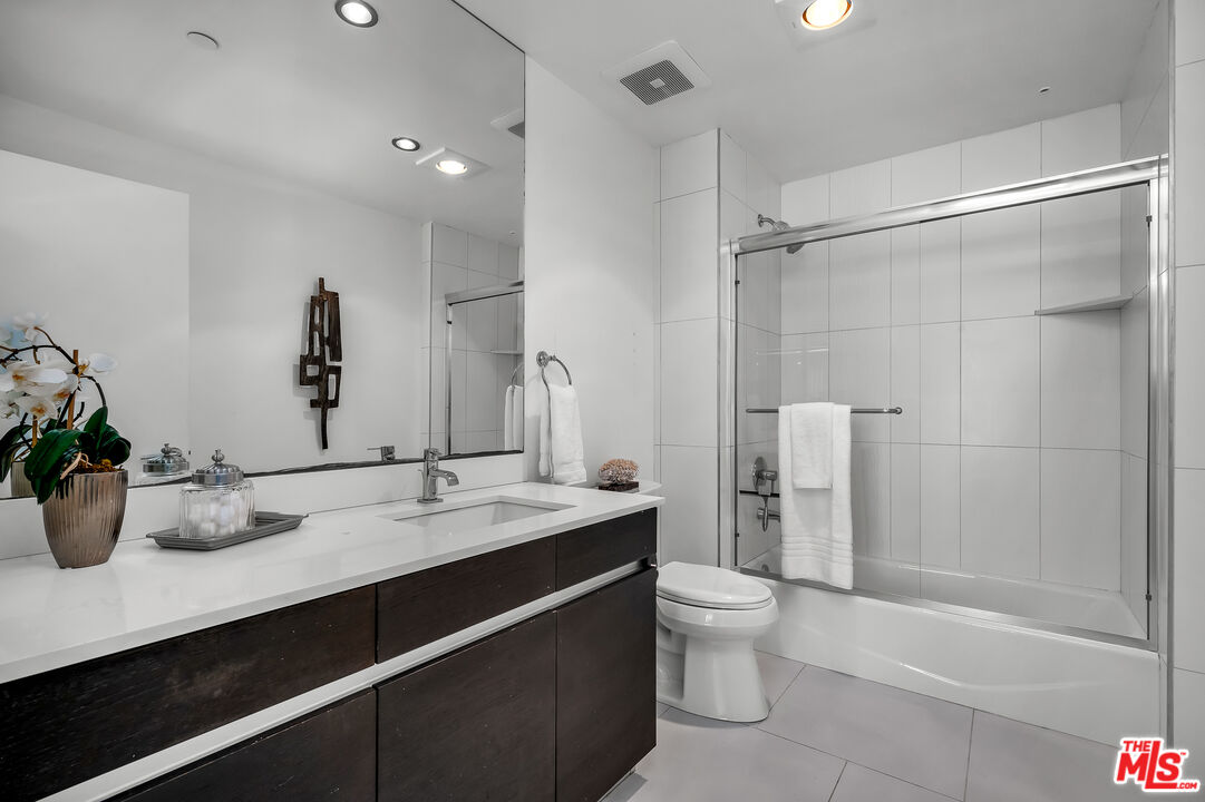 7857 West Manchester Avenue, Unit 201 Playa del Rey, CA 90293 - Photo 20 of 28 a bathroom with a granite countertop sink a toilet and shower