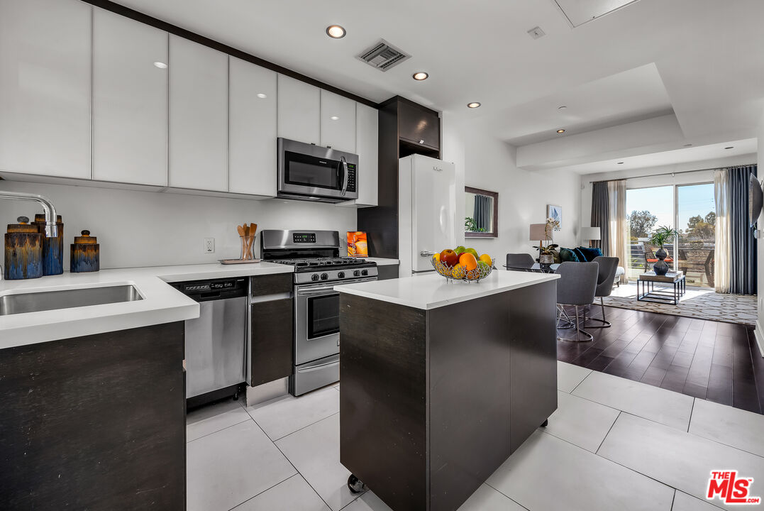 7857 West Manchester Avenue, Unit 201 Playa del Rey, CA 90293 - Photo 5 of 28 a kitchen with stainless steel appliances a stove a sink a microwave a refrigerator and cabinets