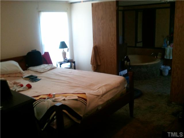 576 Saplin Branch Road Timberlake, NC 27583 - Photo 3 of 8 a bed sitting in a bedroom next to a window