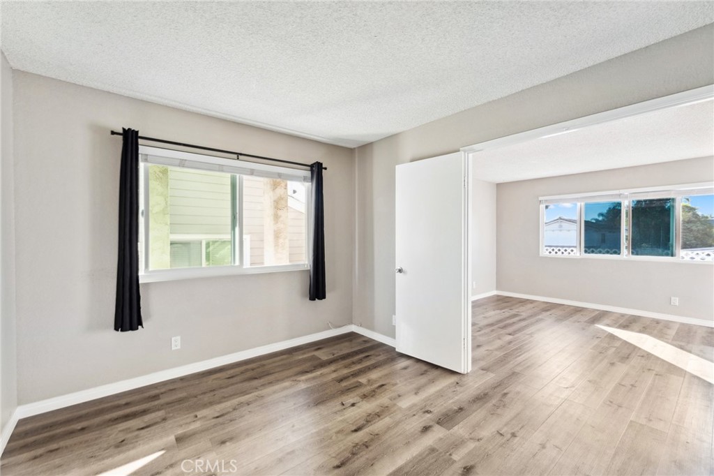 34602 Calle Rosita, Unit A Dana Point, CA 92624 - Photo 15 of 27 a view of an empty room with wooden floor and a window