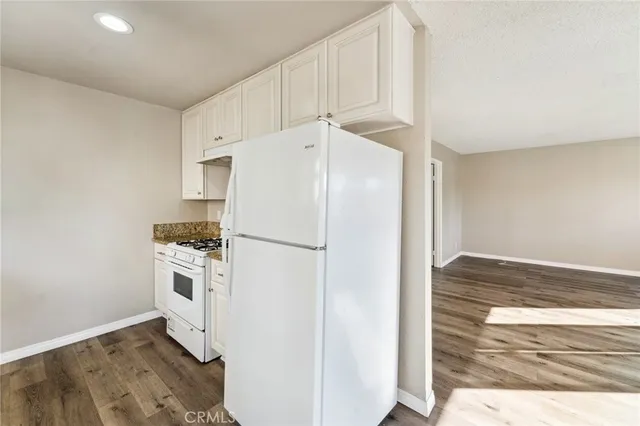 a white refrigerator freezer and a stove sitting inside of a kitchen