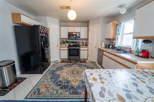 a kitchen with stainless steel appliances granite countertop a refrigerator stove and sink