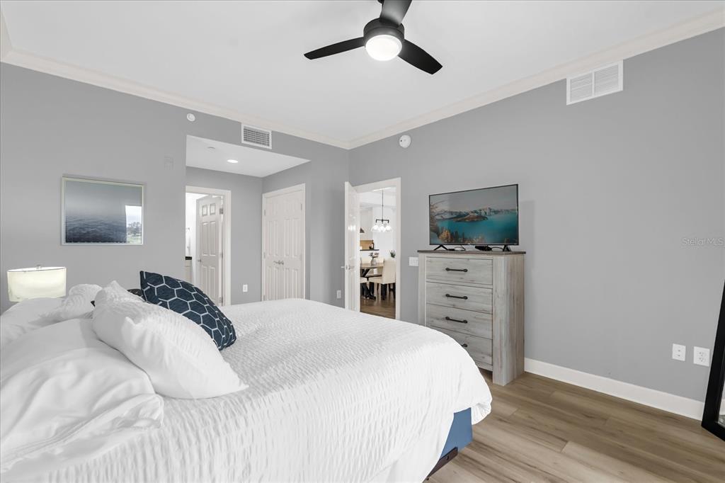 1362 Centre Ct Ridge Drive, Unit 102 Reunion, FL 34747 - Photo 12 of 35 a bedroom with a bed and a flat tv screen on dresser