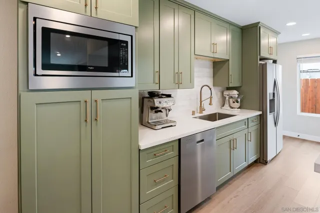 a kitchen with stainless steel appliances granite countertop a sink and a microwave