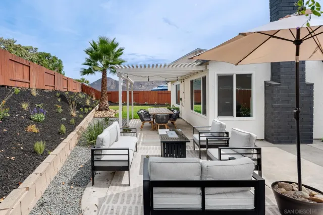 a view of a patio with couches table and chairs and potted plants