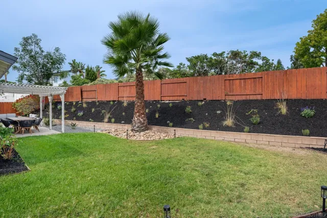 a view of a patio with table and chairs potted plants with wooden fence