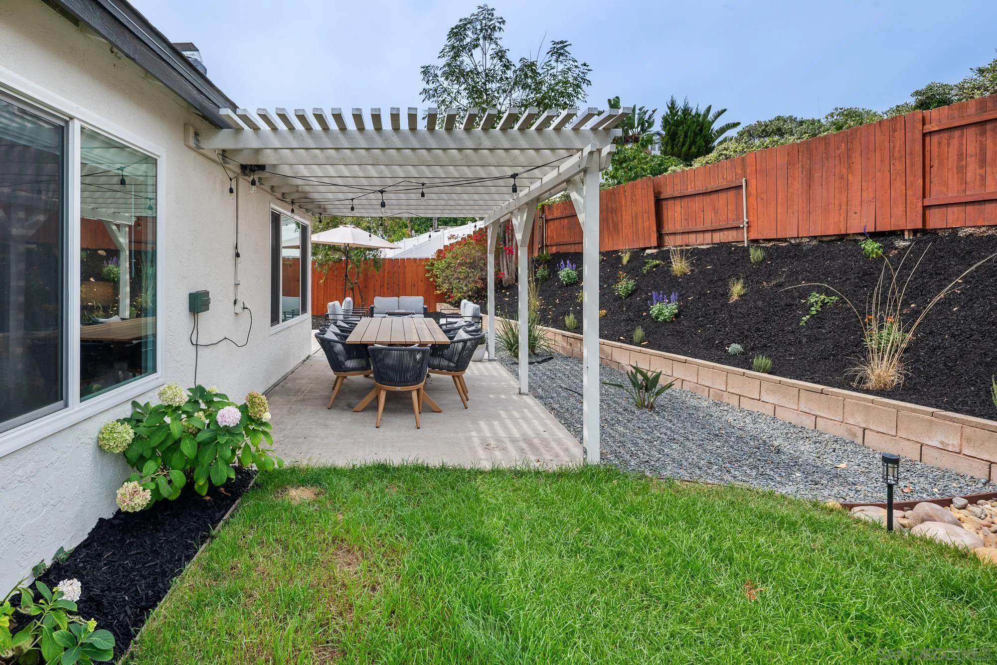6832 Lazy Clouds San Diego, CA 92120 - Photo 37 of 45 a view of a patio with table and chairs potted plants with wooden fence