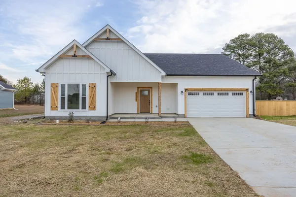 a view of a house with a yard and large tree