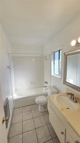 a bathroom with a granite countertop sink a toilet a mirror and bathtub