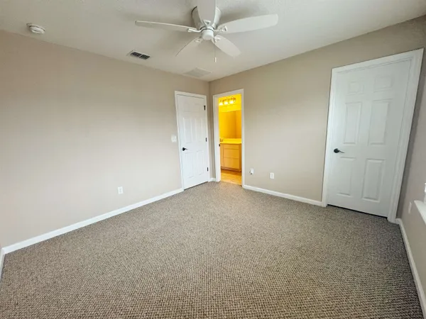 an empty room with a ceiling fan and a window