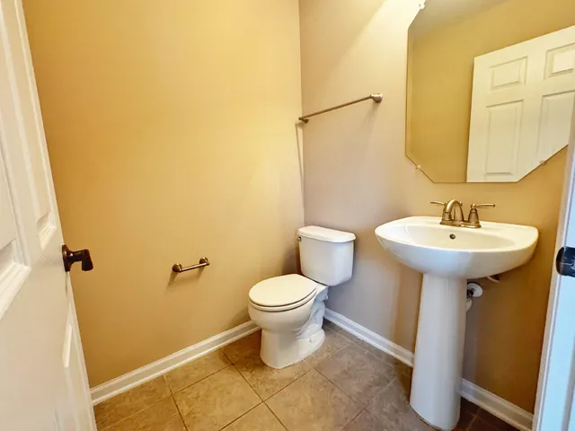 a bathroom with a sink toilet and a mirror