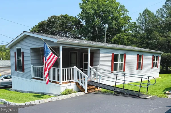 a front view of house with yard and trees in the background