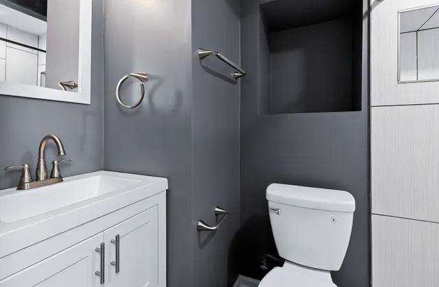 an empty room with a chandelier fan and windows