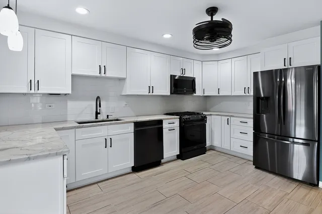 a kitchen with stainless steel appliances granite countertop a sink stove and refrigerator