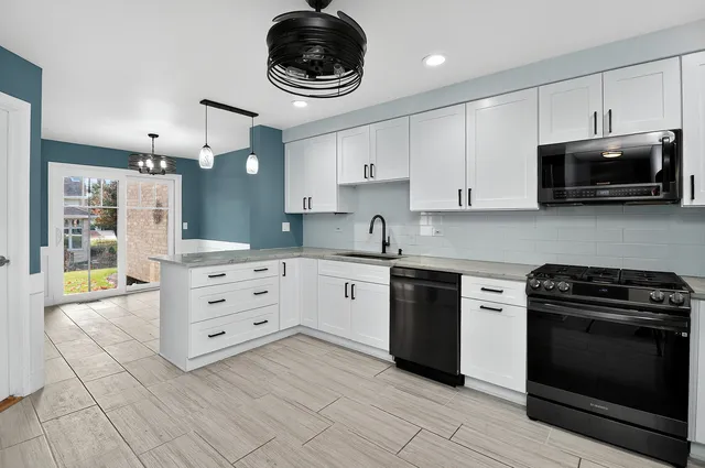 a kitchen with stainless steel appliances a stove a sink and a cabinets