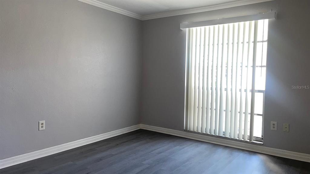 4211 Sheldon Place, Unit 4211 New Port Richey, FL 34652 - Photo 11 of 58 an empty room with wooden floor and windows