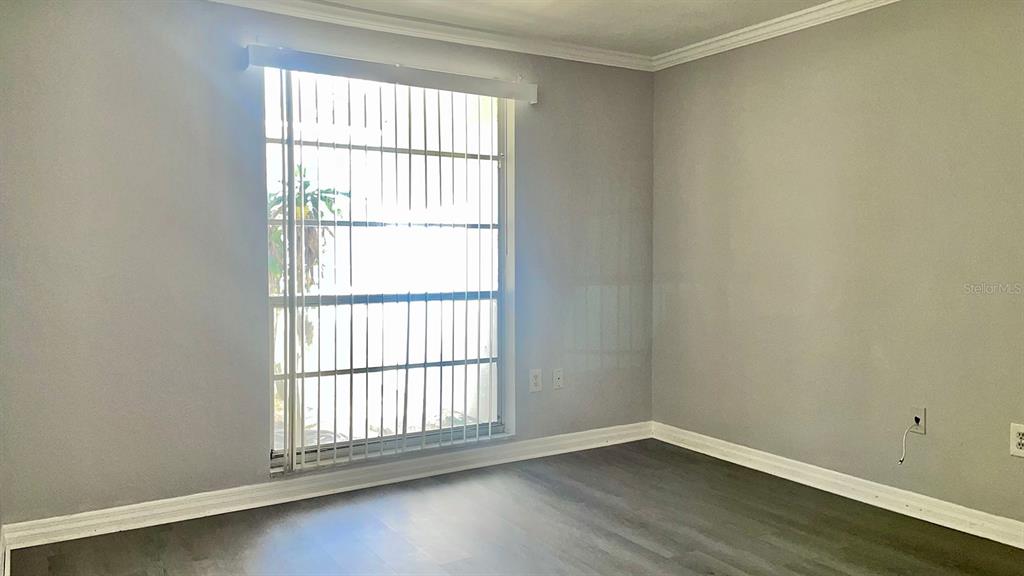 4211 Sheldon Place, Unit 4211 New Port Richey, FL 34652 - Photo 13 of 58 an empty room with wooden floor and windows