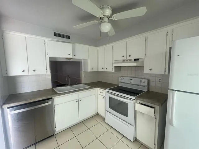 a kitchen with cabinets stainless steel appliances and a counter space