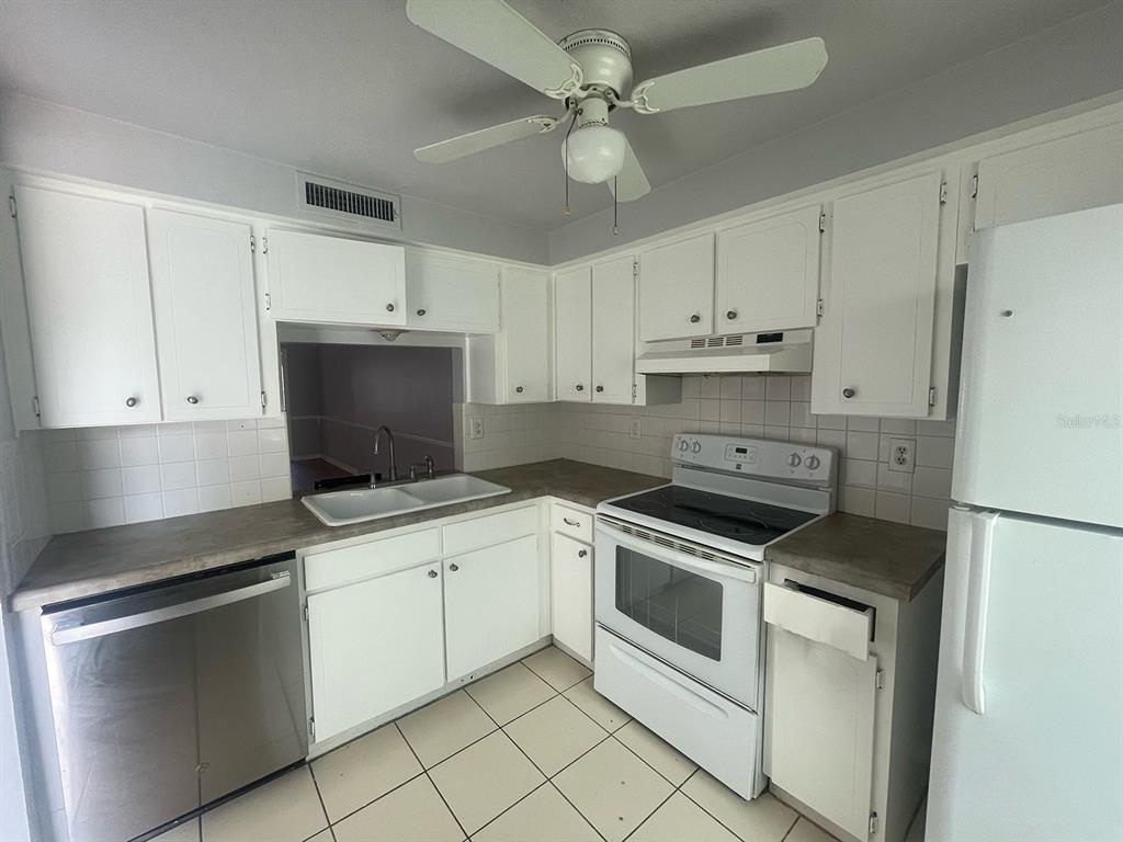 4211 Sheldon Place, Unit 4211 New Port Richey, FL 34652 - Photo 3 of 58 a kitchen with cabinets stainless steel appliances and a counter space