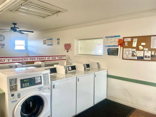 a patio with a table and chairs and potted plants