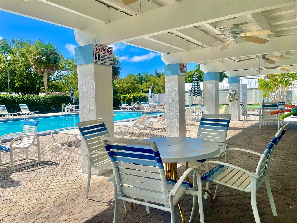 4211 Sheldon Place, Unit 4211 New Port Richey, FL 34652 - Photo 50 of 58 a patio with a table and chairs and potted plants