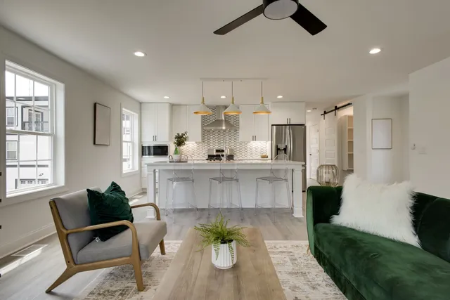 a living room with kitchen island furniture and a chandelier