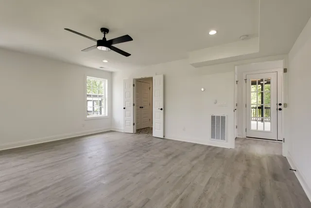 a view of empty room with wooden floor and window