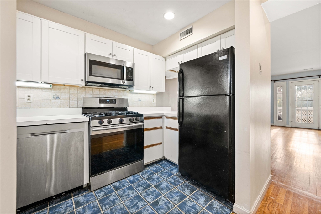 36 Cummings Road, Unit 10 Boston, MA 02135 - Photo 8 of 17 a kitchen with a refrigerator stove and white cabinets