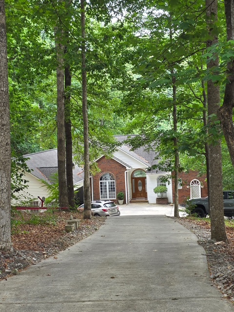 214 Berwick Court Seneca, SC 29672 - Photo 36 of 39 A long, winding driveway leads to a private residence, nestled amongst mature trees and lush greenery.