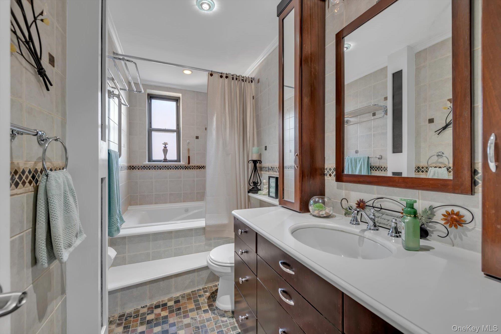 83-25 98th Street, Unit 4L Queens, NY 11421 - Photo 13 of 14 Bathroom featuring tile walls, vanity, tiled shower / bath, and crown molding