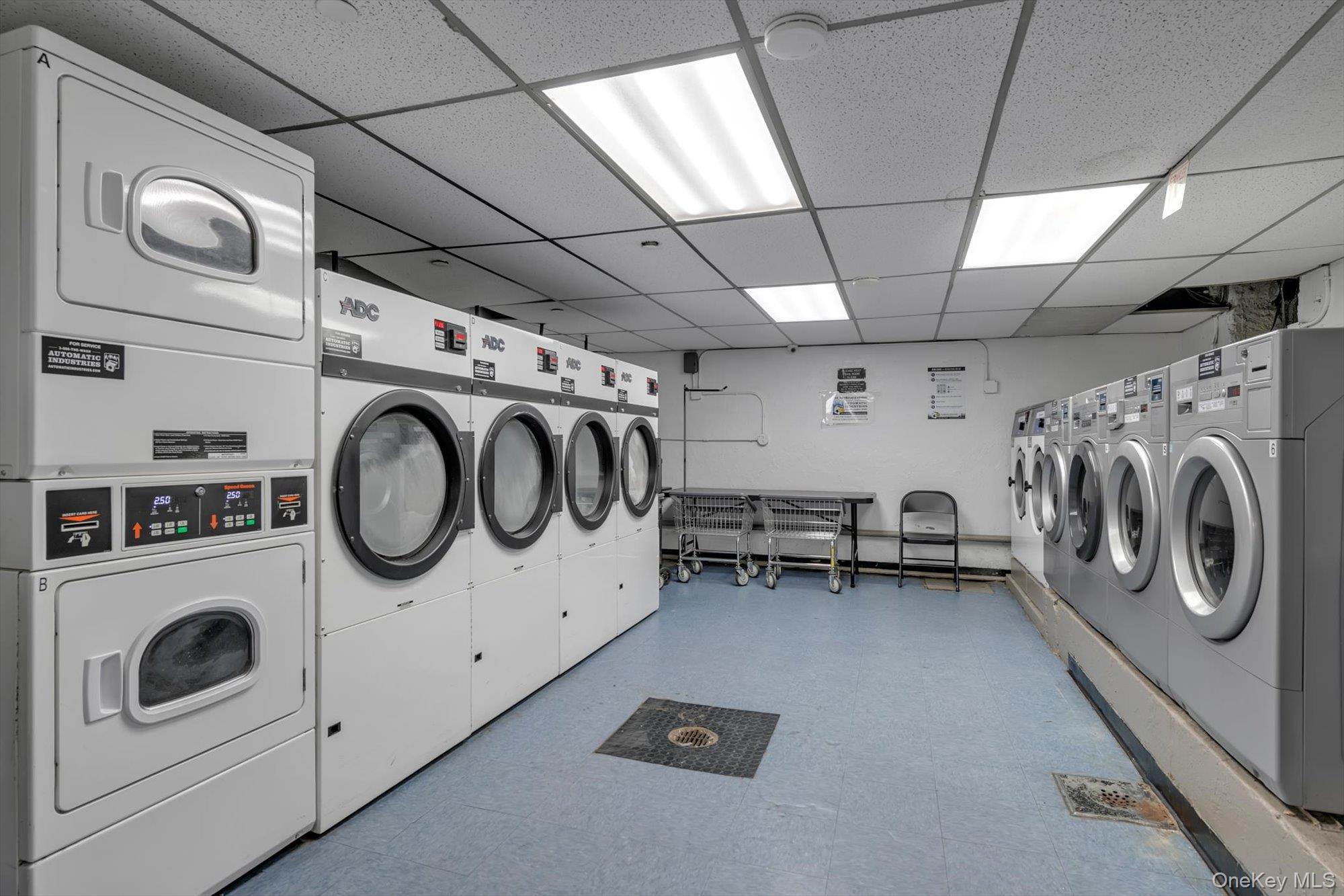 83-25 98th Street, Unit 4L Queens, NY 11421 - Photo 14 of 14 Washroom featuring a paneled ceiling, stacked washer / drying machine, and washing machine and clothes dryer