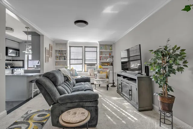 a living room with furniture a flat screen tv and a floor to ceiling window