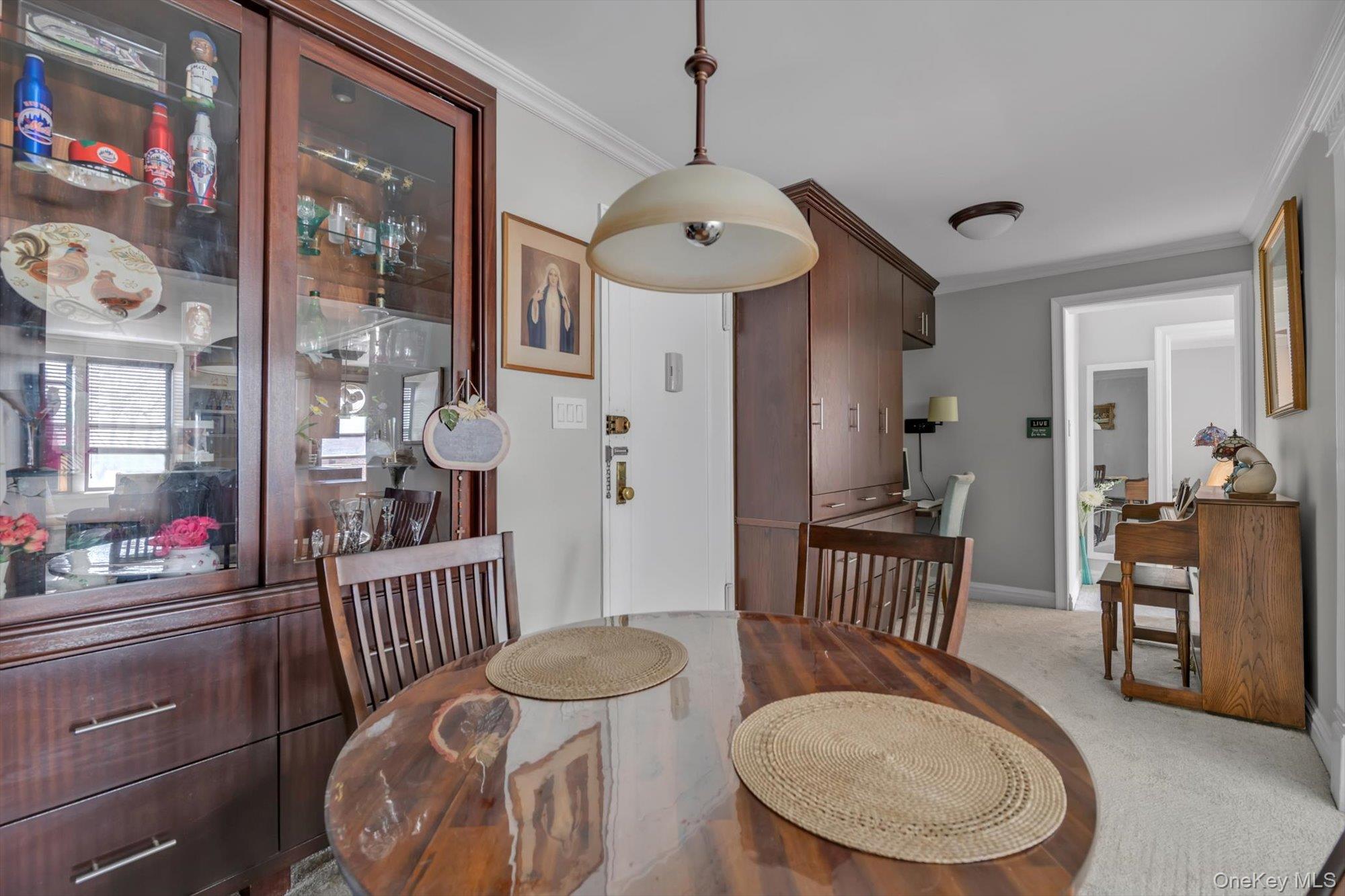 83-25 98th Street, Unit 4L Queens, NY 11421 - Photo 9 of 14 Dining room with crown molding and light colored carpet