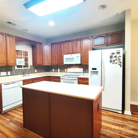 a kitchen with stainless steel appliances granite countertop a refrigerator a sink and a stove